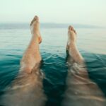 person's legs on water