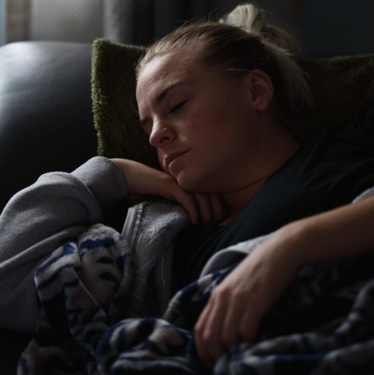 woman in black shirt lying on couch