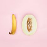 Artistic arrangement of banana and melon on pink background, representing playful concepts.