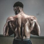 A shirtless man displaying his muscular back, showcasing strength and fitness.