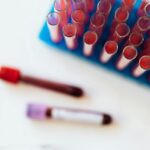 Top view of glass covered tubes arranged on table near plastic stand with tubes placed on row in modern laboratory