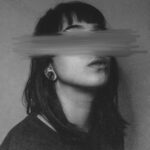 Artistic black and white portrait with blurred face evokes anonymity and emotion.