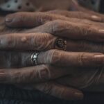 Intimate close-up of elderly hands adorned with rings, showcasing wrinkles and age.