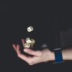 A close-up of a hand tossing several dice against a dark background, symbolizing chance and luck.