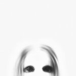 A ghostly figure with black eyes emerges from a blurred white background, creating a spooky atmosphere.