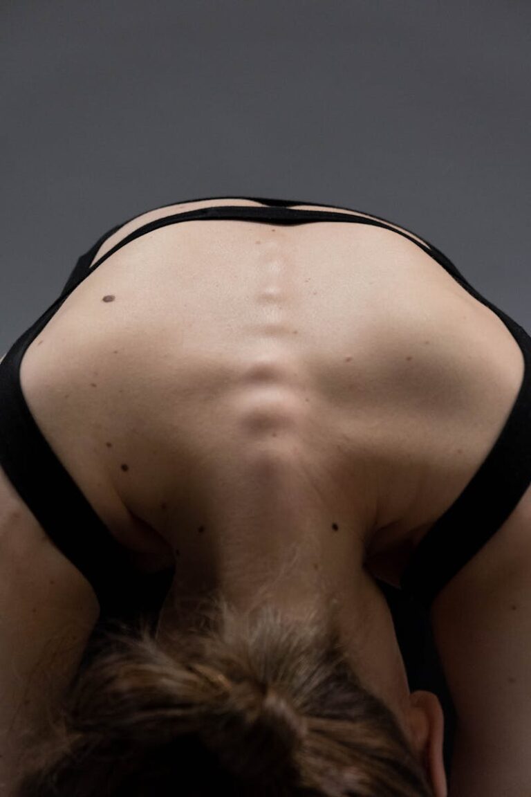 Close-up of a woman in a yoga pose highlighting the spine and back muscles.