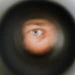 a man's eye is seen through a pipe