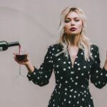 Chic woman enjoying wine and smoking, showcasing modern lifestyle and elegance.