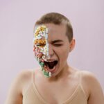 A striking portrait of a young woman with pills arranged on her face, evoking themes of health and medicine.