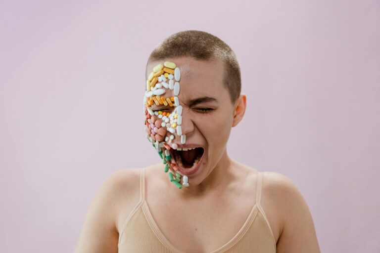 A striking portrait of a young woman with pills arranged on her face, evoking themes of health and medicine.