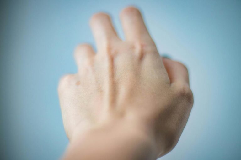 Artistic depiction of a blurred hand reaching against a blue background.