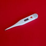white thermometer on red surface